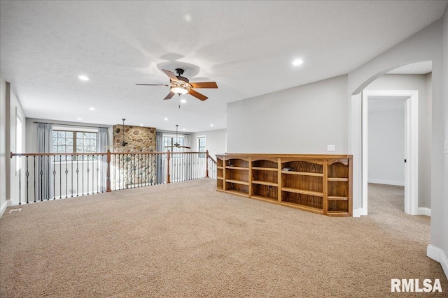 basement with ceiling fan, carpet, and a textured ceiling