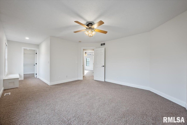 carpeted empty room featuring ceiling fan and a textured ceiling