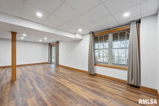 basement with a paneled ceiling and hardwood / wood-style floors