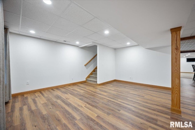 basement with a drop ceiling and hardwood / wood-style floors