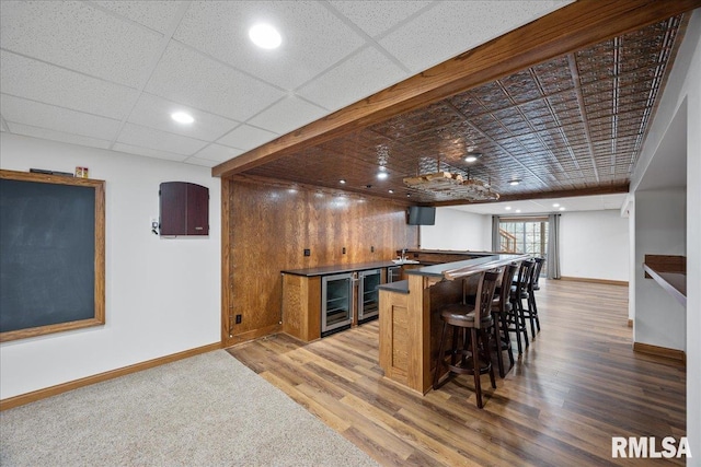 bar featuring hardwood / wood-style floors and beverage cooler