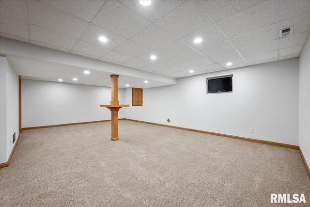 basement featuring a paneled ceiling and carpet flooring