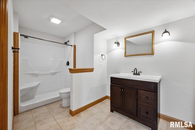 bathroom featuring vanity, tile patterned floors, toilet, and a shower