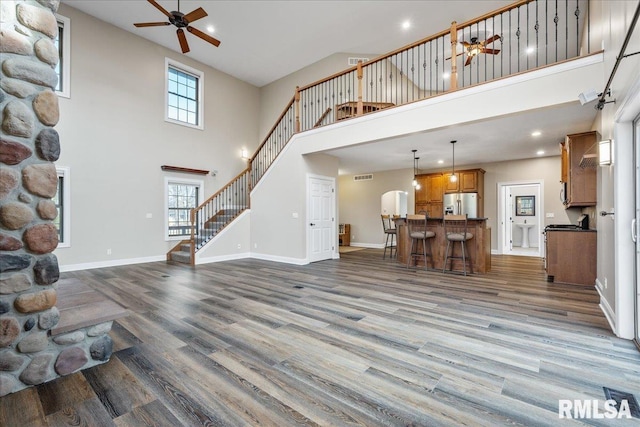 living room featuring sink, dark wood-type flooring, ceiling fan, and a high ceiling