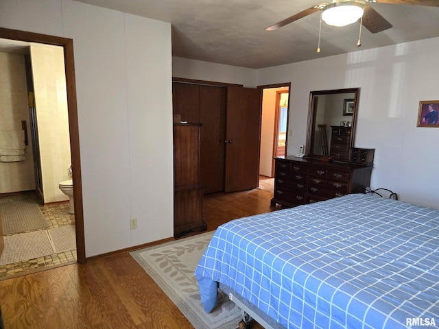 bedroom featuring ceiling fan, connected bathroom, a closet, and light wood-type flooring