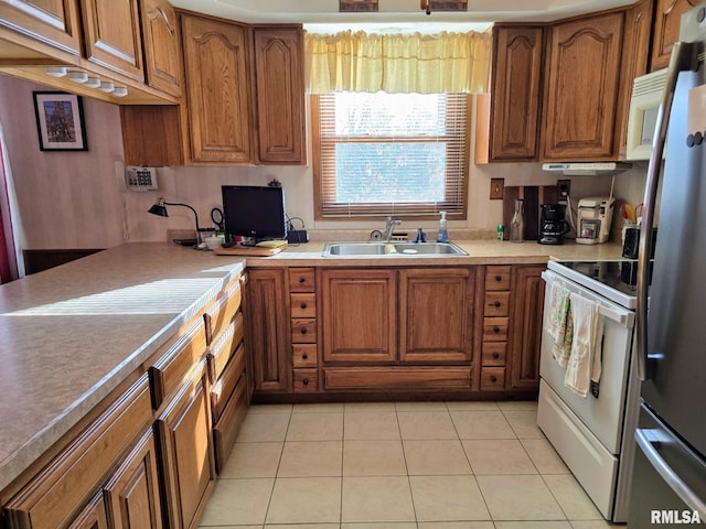 kitchen with stainless steel refrigerator, light tile patterned floors, sink, and white range with electric stovetop