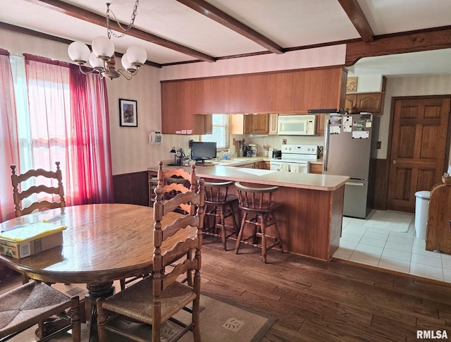 dining space featuring beamed ceiling, wood-type flooring, plenty of natural light, and a chandelier