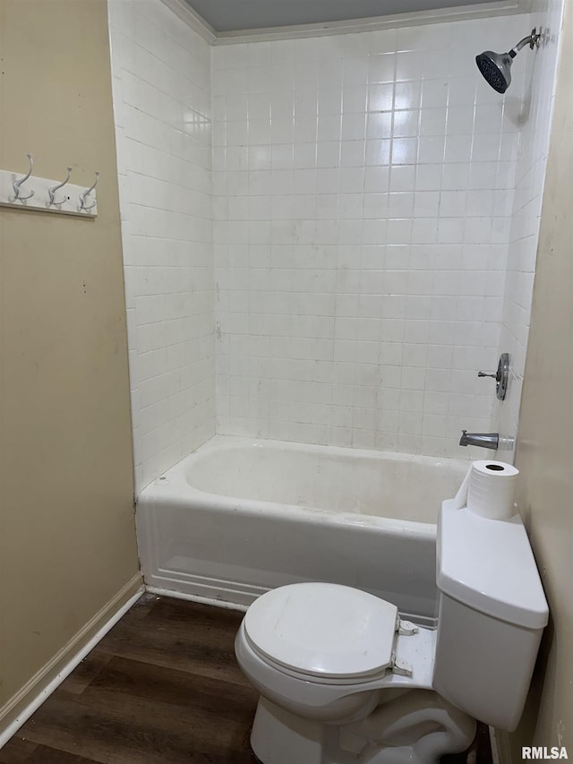 bathroom with wood-type flooring, toilet, and tiled shower / bath combo