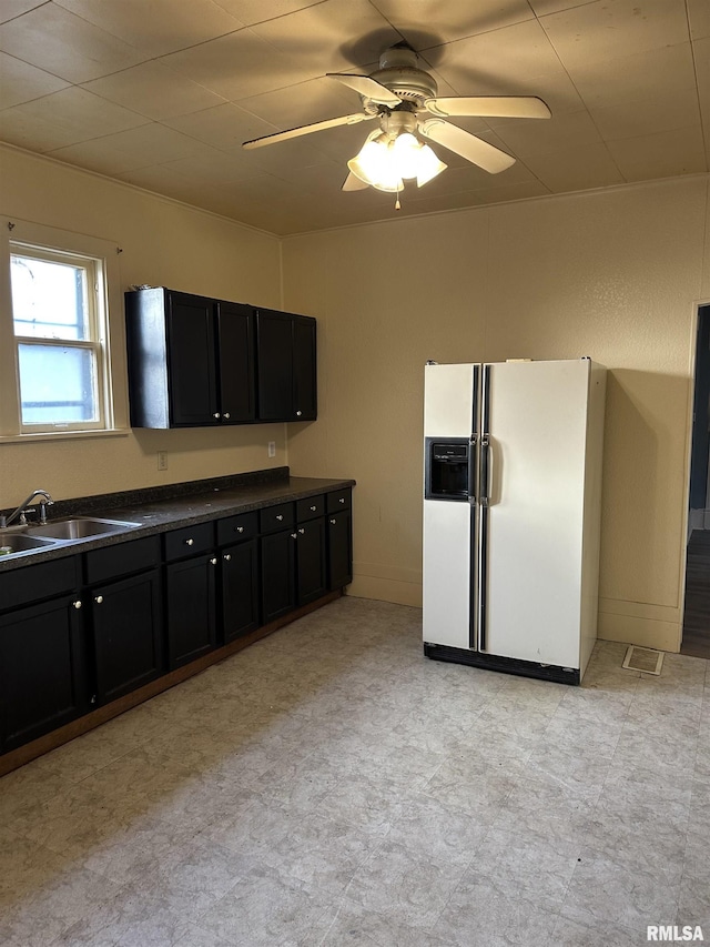 kitchen featuring white refrigerator with ice dispenser, sink, and ceiling fan