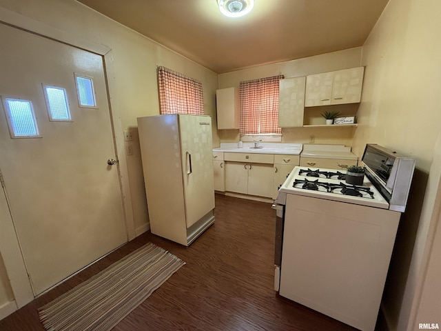 kitchen featuring sink, dark hardwood / wood-style floors, and white gas range oven