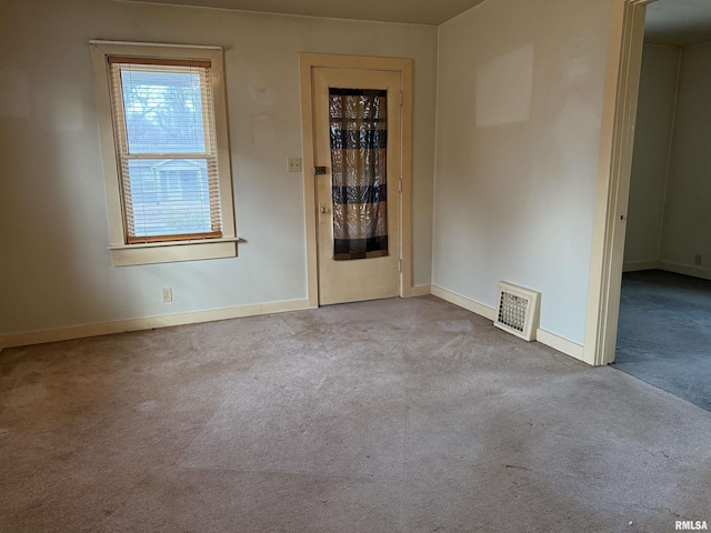 spare room featuring light carpet