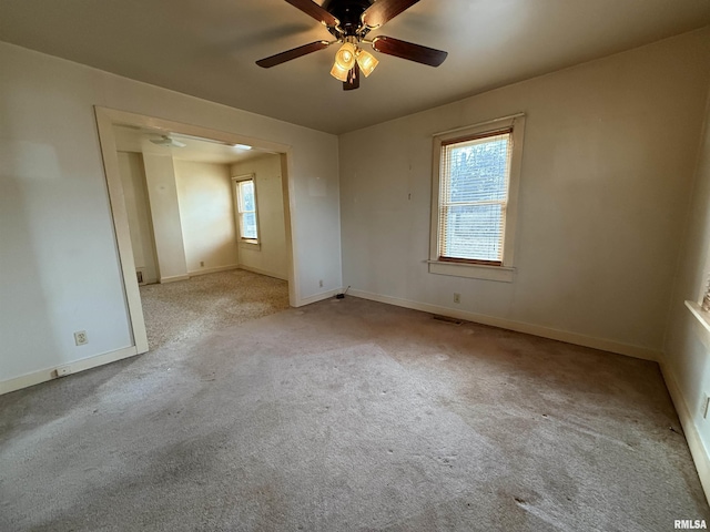 carpeted spare room featuring ceiling fan