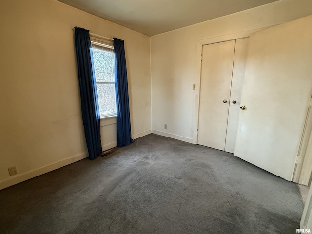 unfurnished bedroom with dark carpet