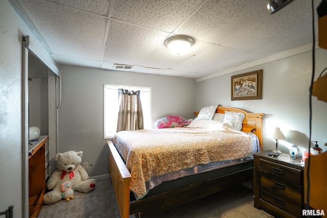 carpeted bedroom featuring a paneled ceiling