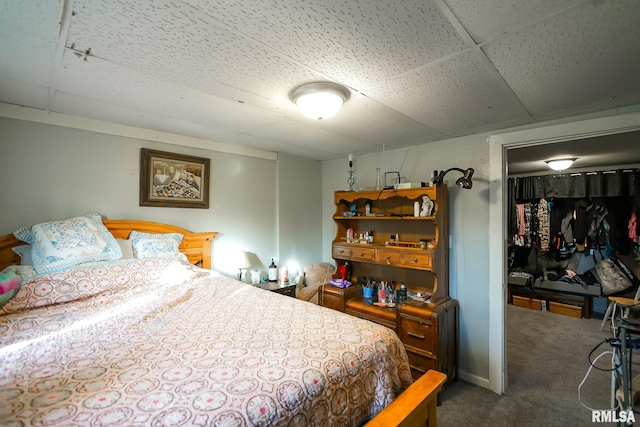 carpeted bedroom with a paneled ceiling and a closet