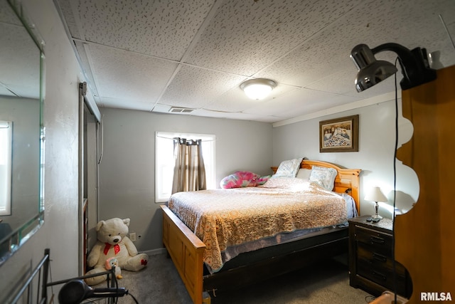 bedroom featuring a paneled ceiling and carpet flooring