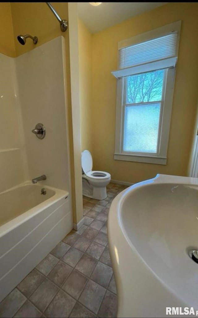 bathroom with tile patterned floors, tub / shower combination, and toilet