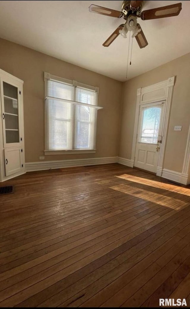 interior space with dark wood-type flooring and ceiling fan