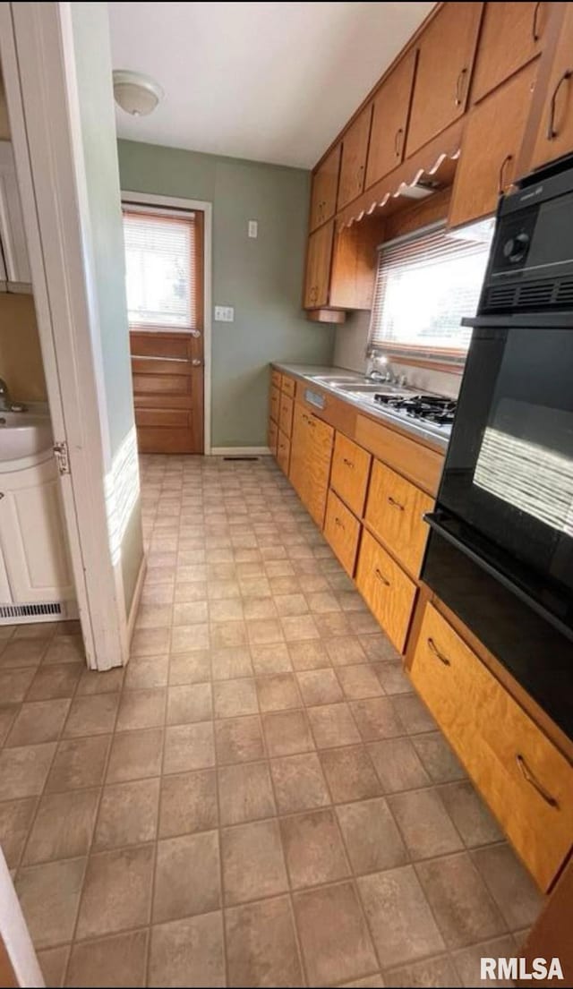 kitchen with oven, a healthy amount of sunlight, and stainless steel gas cooktop