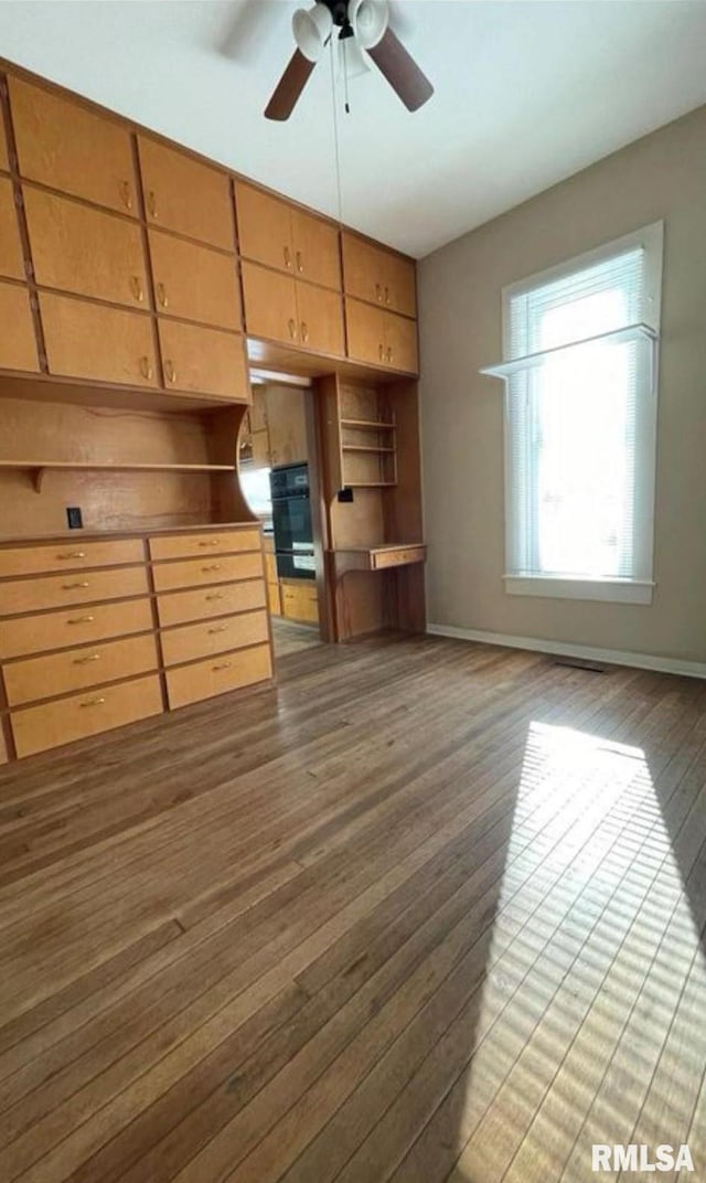 unfurnished living room with wood-type flooring and ceiling fan