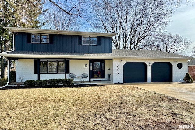 front of property featuring a garage, covered porch, and a front yard