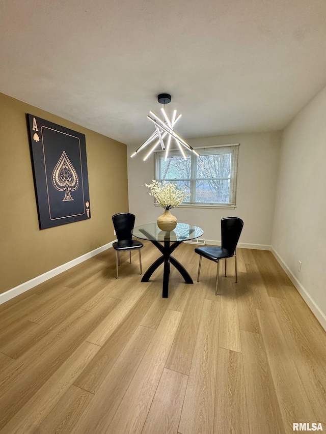 unfurnished room featuring an inviting chandelier and light hardwood / wood-style flooring