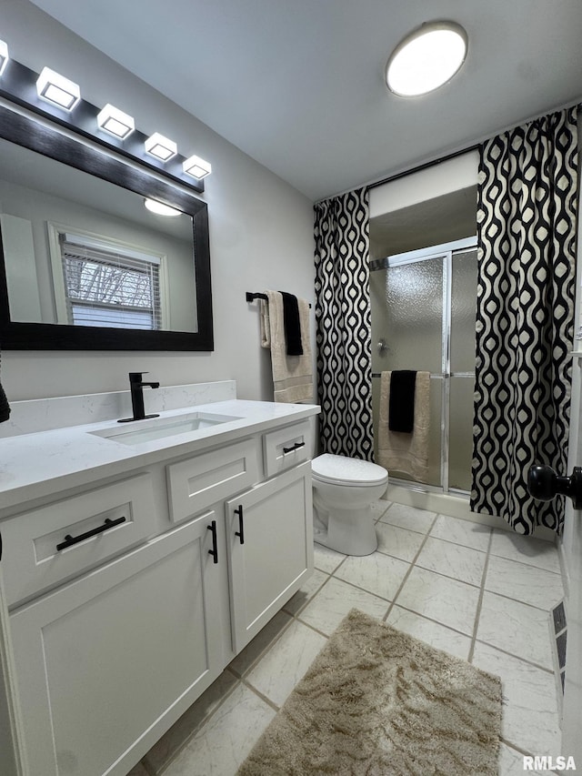 bathroom with vanity, toilet, and a shower with shower door