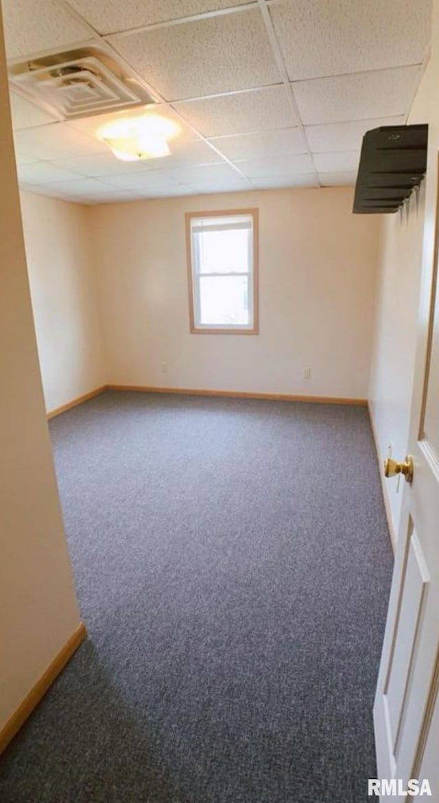 unfurnished room featuring a paneled ceiling and carpet floors