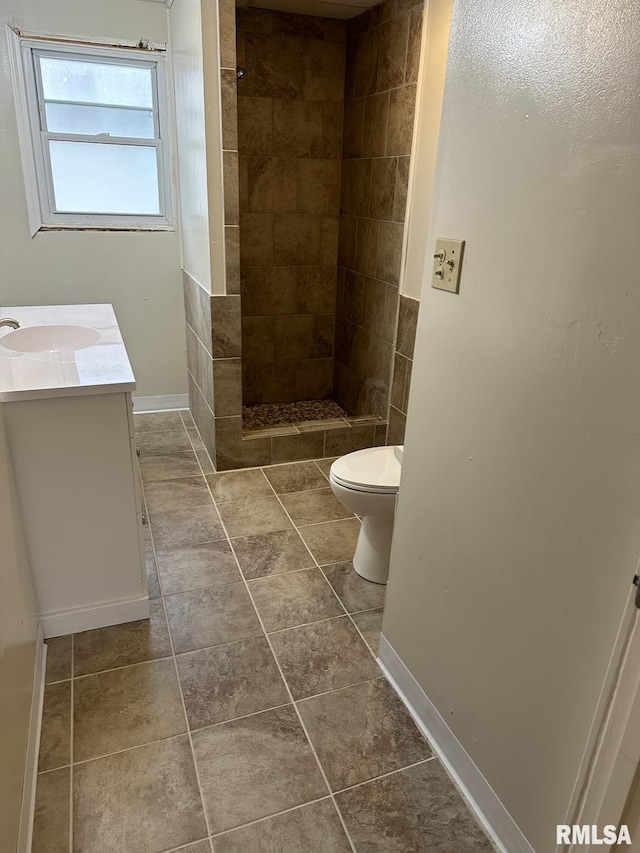 bathroom featuring tiled shower, vanity, toilet, and tile patterned floors