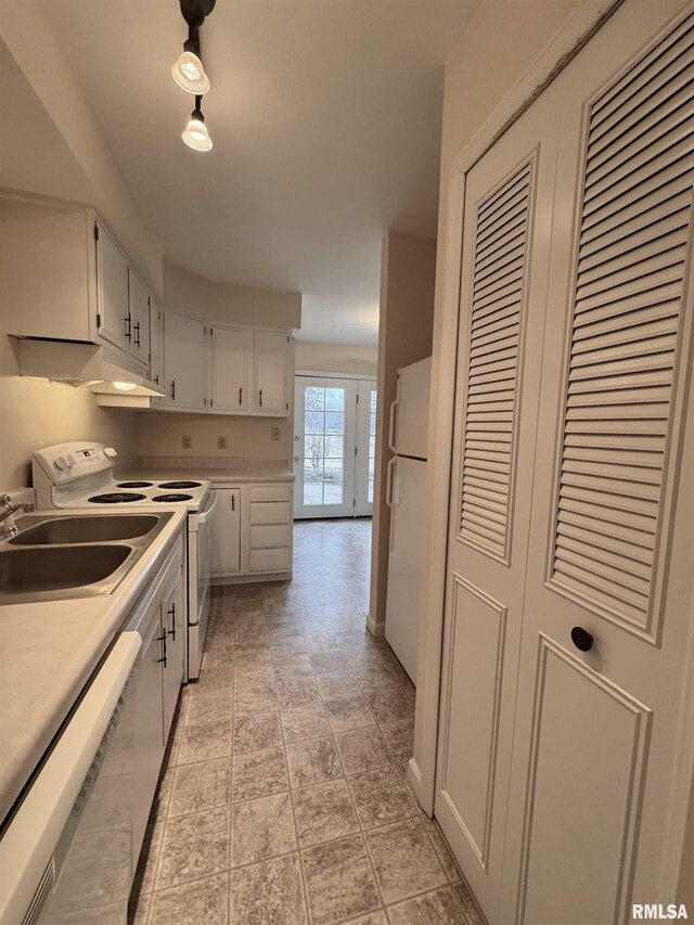 kitchen with white cabinetry, sink, and white appliances