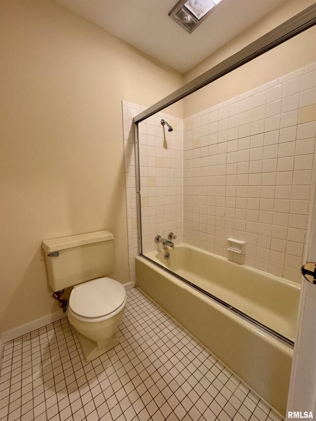 bathroom featuring tiled shower / bath, toilet, and tile patterned flooring