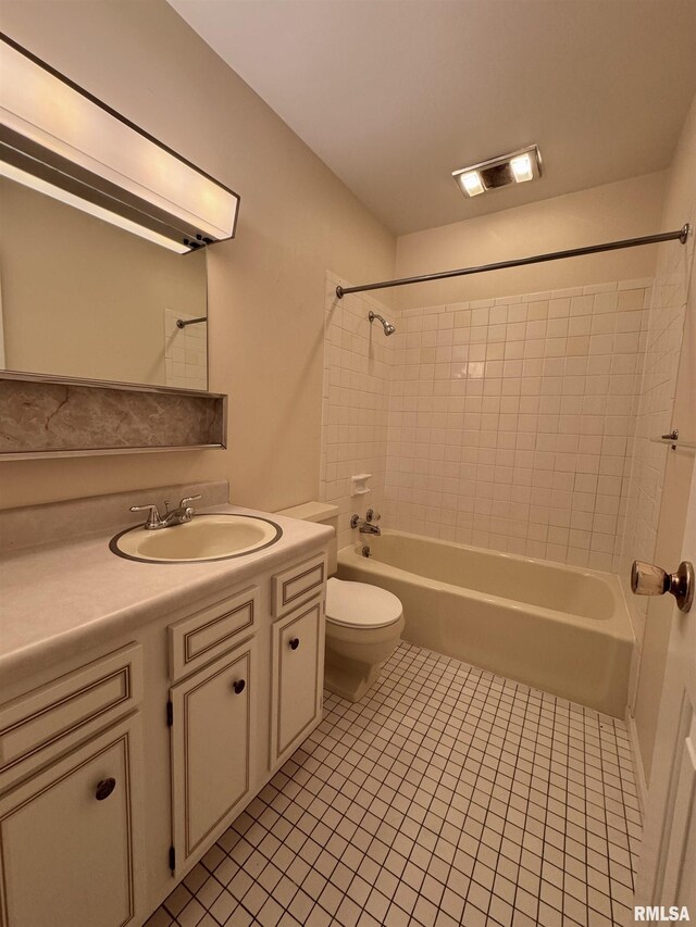 full bathroom with vanity, tile patterned flooring, tiled shower / bath combo, and toilet