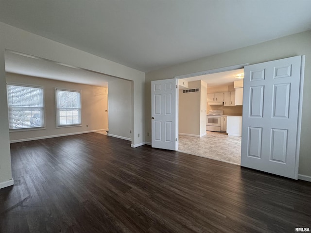 unfurnished living room featuring dark hardwood / wood-style floors