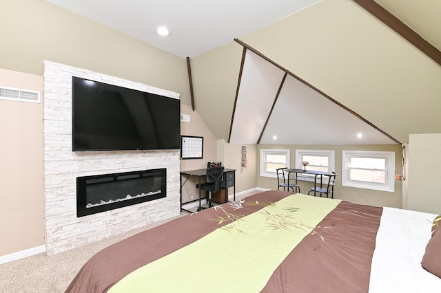 carpeted bedroom with vaulted ceiling and a fireplace