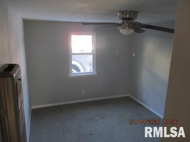 carpeted spare room featuring radiator and ceiling fan