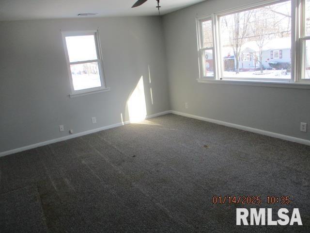 carpeted spare room featuring ceiling fan