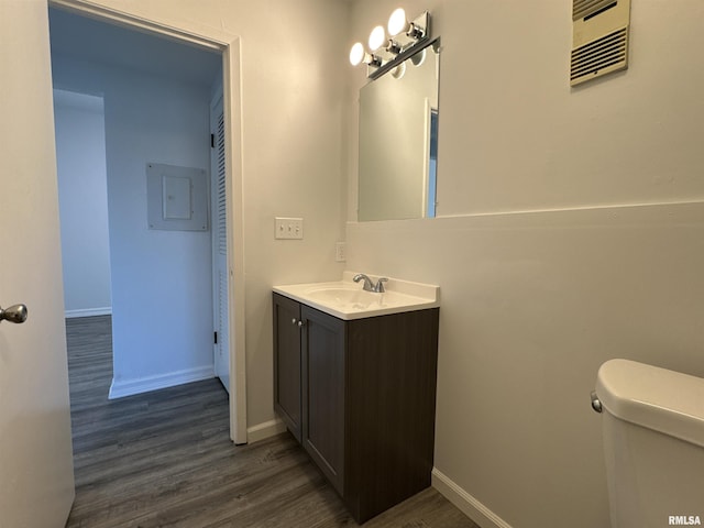 bathroom with vanity, hardwood / wood-style floors, electric panel, and toilet