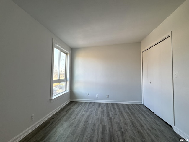 unfurnished bedroom featuring dark wood-type flooring and a closet