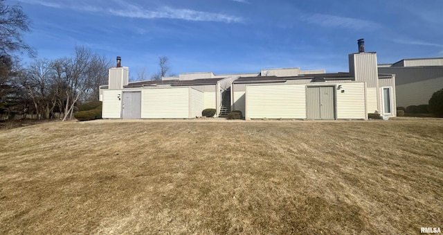 rear view of house featuring a yard