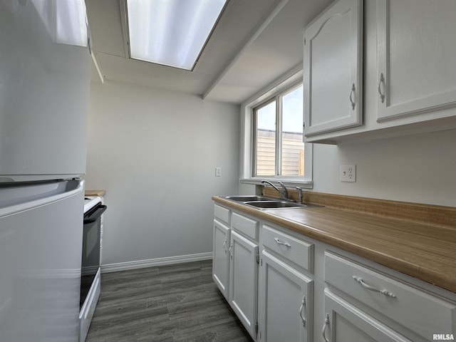 kitchen with sink, dark wood-type flooring, white range with electric cooktop, fridge, and white cabinets