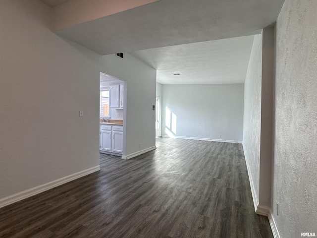 unfurnished room with dark wood-type flooring