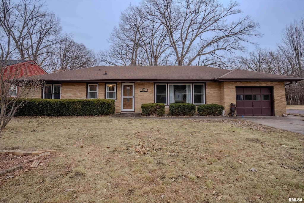 single story home featuring a garage and a front lawn