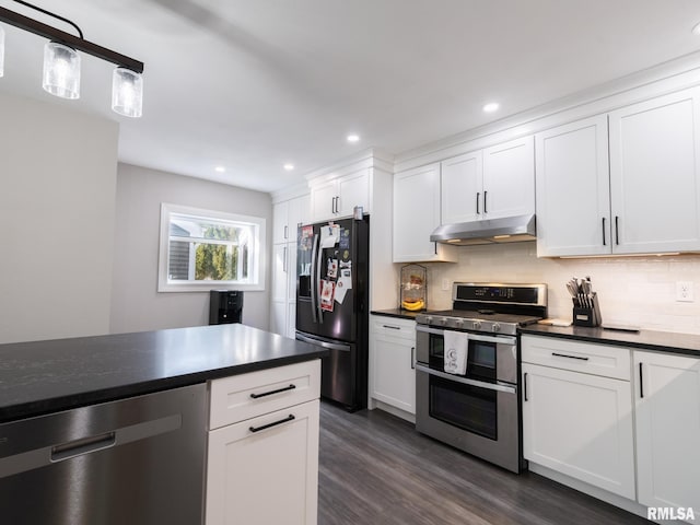 kitchen with white cabinetry, dark hardwood / wood-style flooring, decorative backsplash, hanging light fixtures, and stainless steel appliances