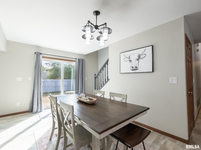 dining area with an inviting chandelier and light hardwood / wood-style flooring