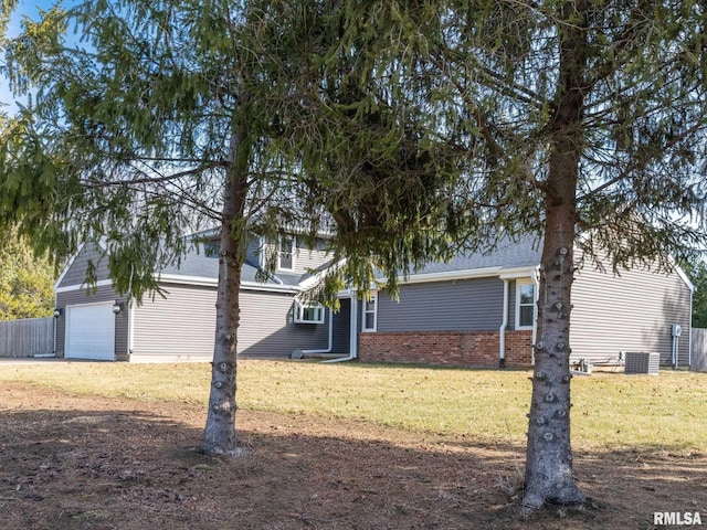 view of side of property featuring a garage, a yard, and central AC