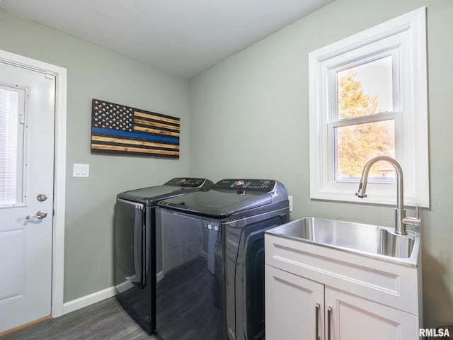 clothes washing area with dark wood-type flooring, cabinets, separate washer and dryer, and sink