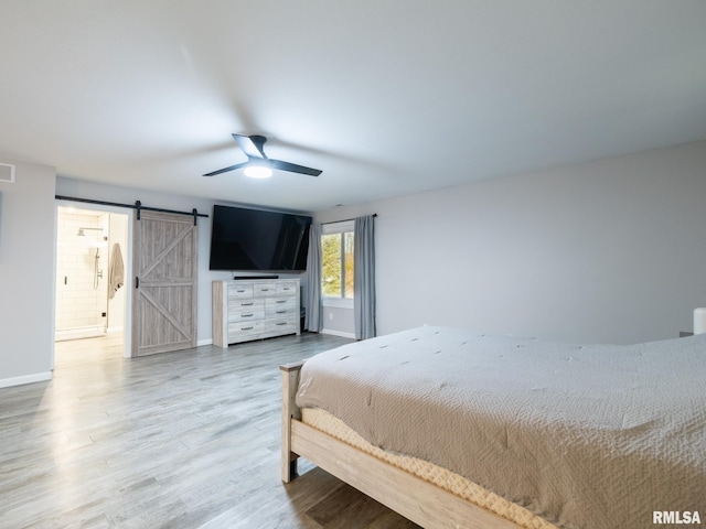 bedroom with wood-type flooring, a barn door, and ceiling fan