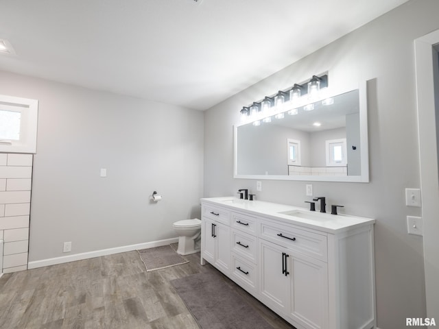 bathroom featuring wood-type flooring, toilet, and vanity