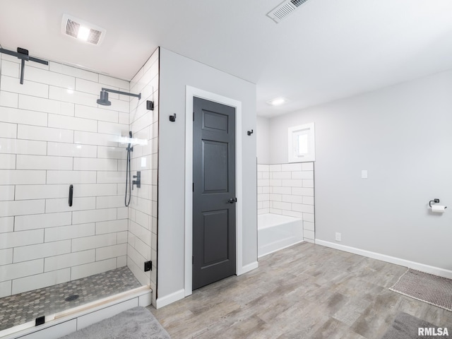 bathroom with an enclosed shower and hardwood / wood-style floors