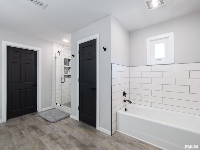 bathroom with wood-type flooring and plus walk in shower